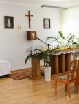Wnętrze Domu Pomocy Społecznej. Pomieszczenie kaplicy. Ołtarz ze stołem mszalnym i mównicą. Na ścianie krzyż, tabernakulum oraz obrazy religijne.